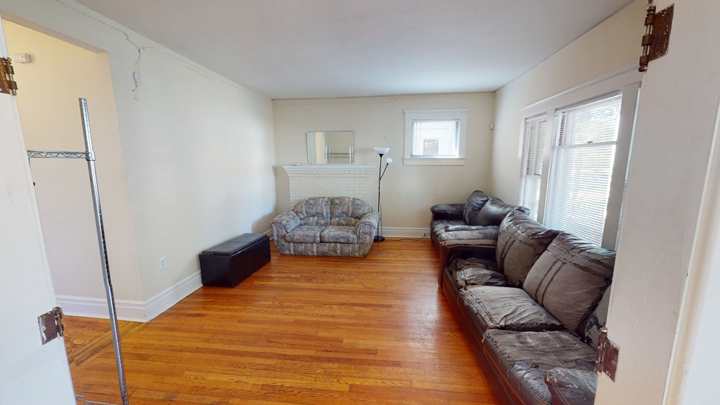 A living room with a couch, chair, and fireplace.