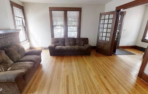 A living room with a brown couch and a brown chair.