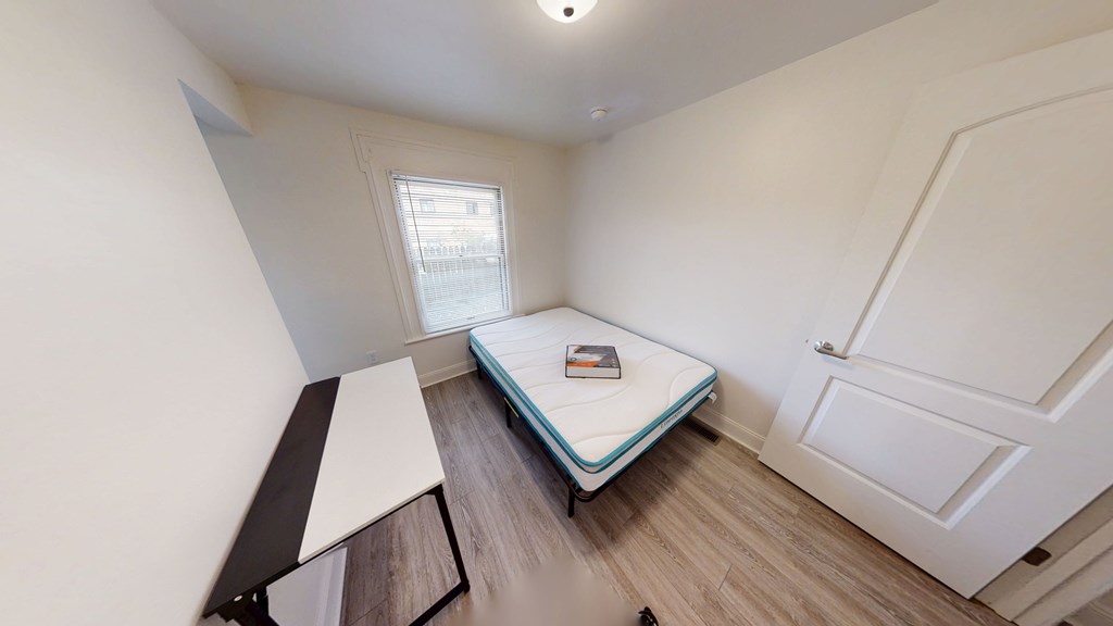 A small bedroom with a single bed and a window.