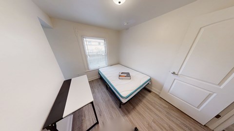 A small bedroom with a single bed and a window.
