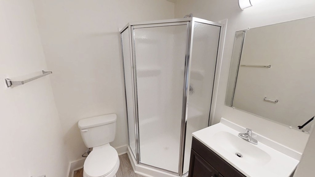 A white toilet sits next to a sink in a small bathroom.
