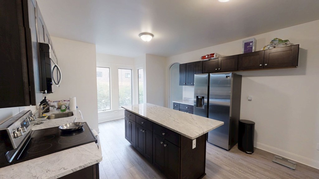 A kitchen with a stove top oven and a refrigerator.