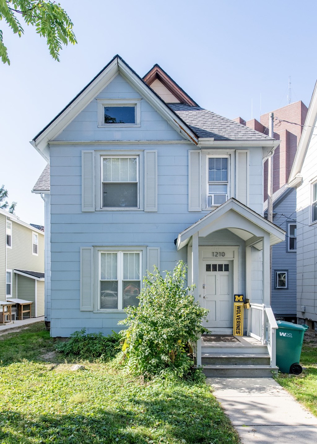 A blue house with a white door and windows.