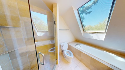 A bathroom with a skylight and a bathtub.