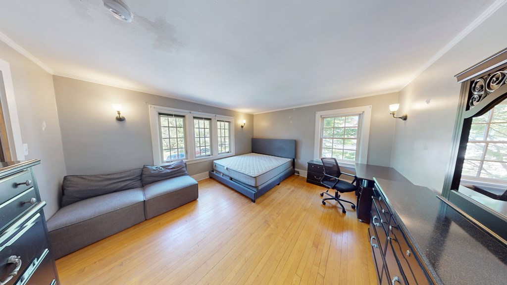 A room with a bed, a couch, and a chair.