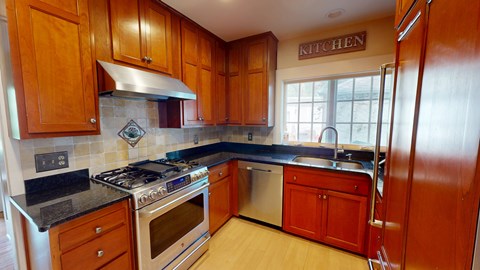 A kitchen with wooden cabinets and a stove top oven.