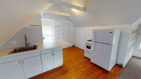 A kitchen with white cabinets and a white refrigerator.