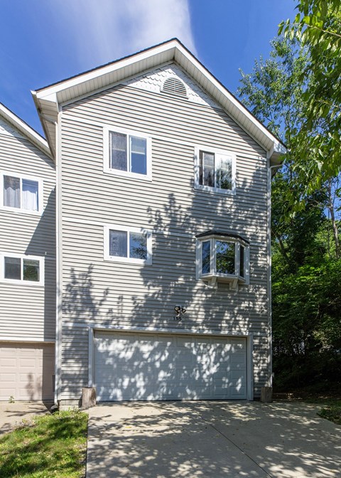 A two-story house with a garage door and a driveway.