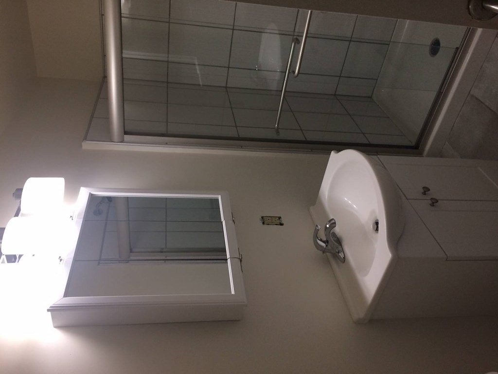 A white urinal and sink in a bathroom.