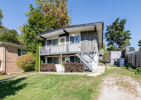 A two-story house with a balcony on the second floor.