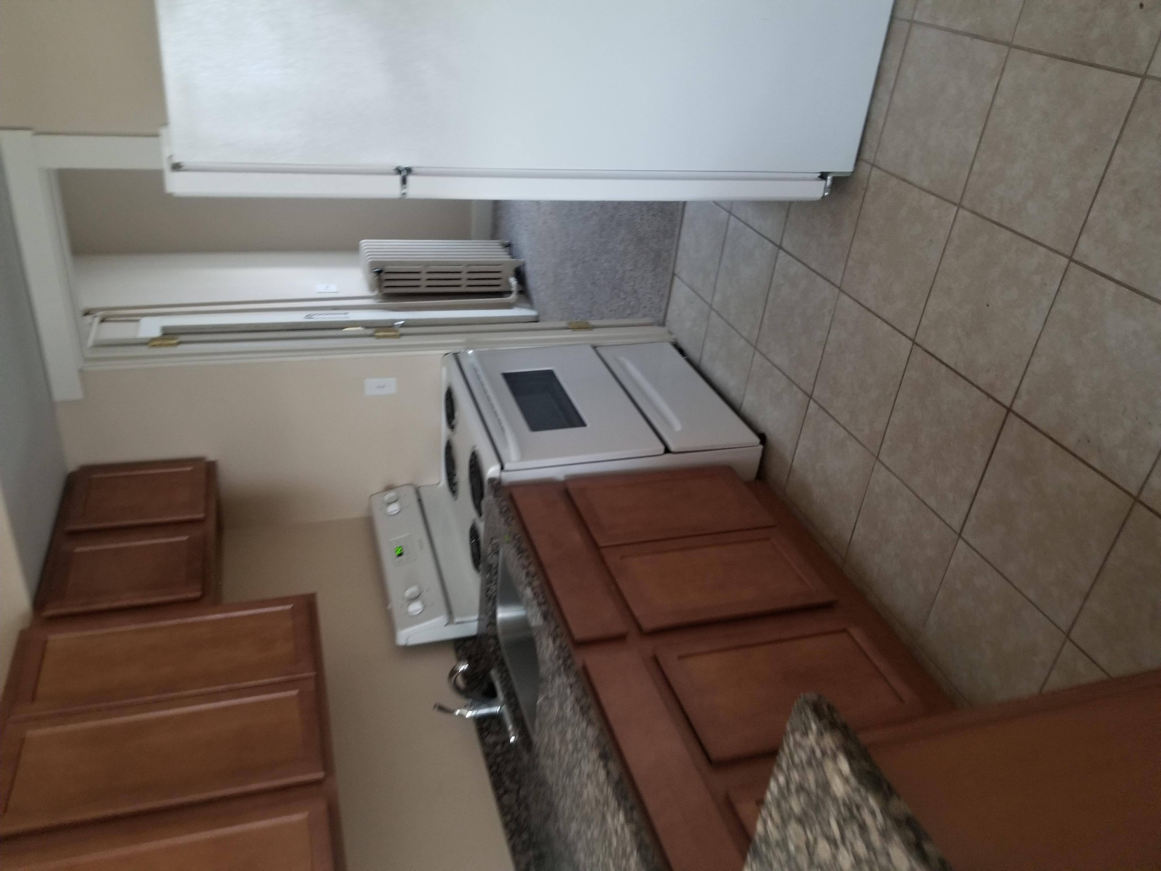A kitchen with brown countertops and a white oven.