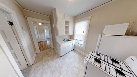 A kitchen with a stove top oven and a refrigerator.