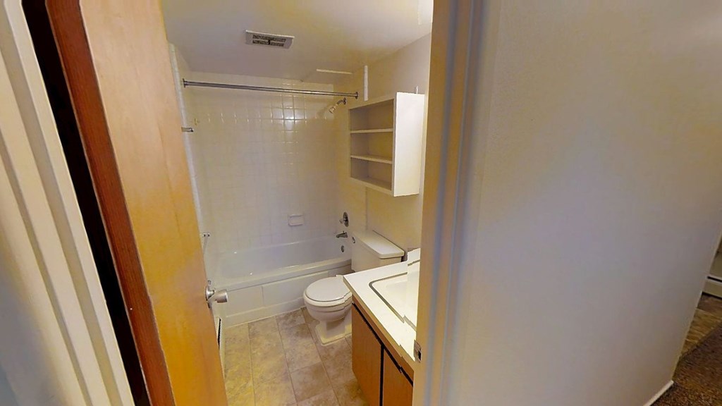 A bathroom with a toilet, sink, and shower.