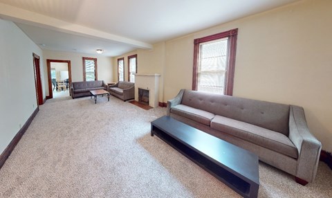 A living room with a grey couch and a black coffee table.