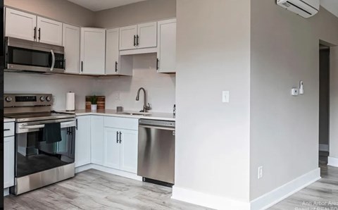 A kitchen with white cabinets and stainless steel appliances.