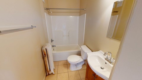 A small bathroom with a toilet, sink, and bathtub.