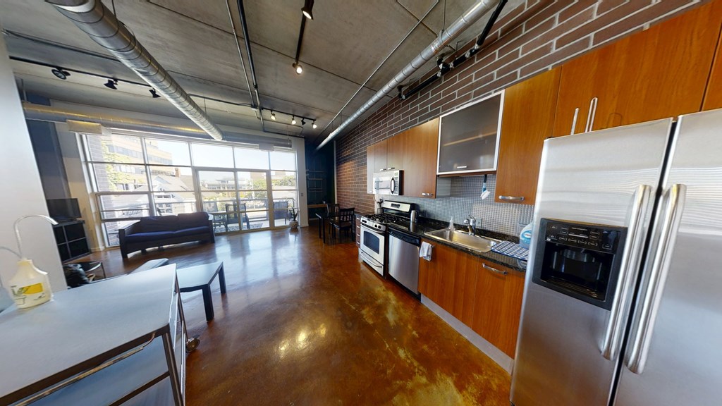 A kitchen with stainless steel appliances and wooden cabinets.