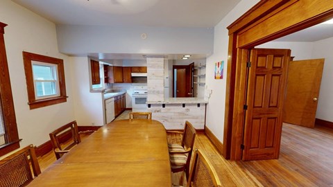 A kitchen with a table and chairs in the foreground.