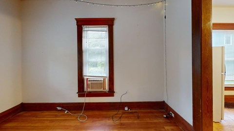 A room with a window and wooden floors.