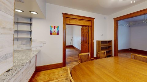 A room with a wooden floor and a stone fireplace.