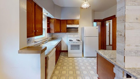 A kitchen with white appliances and wooden cabinets.