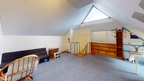 A room with a sofa, chair, and a bed.