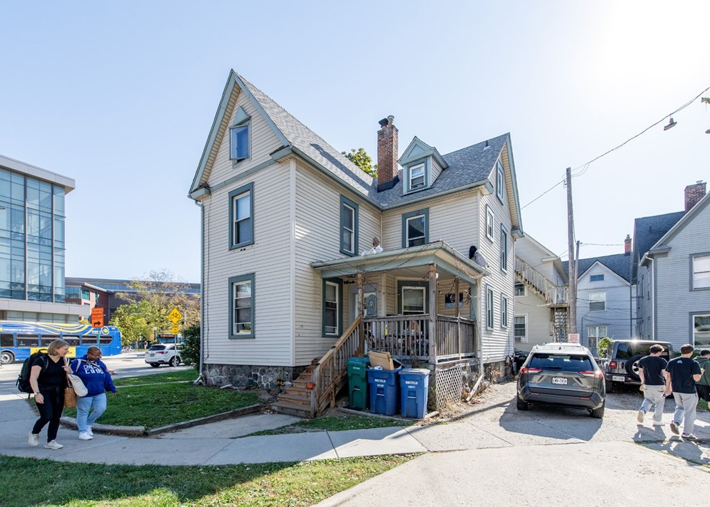 A house with a grey facade and a brown roof with a chimney.