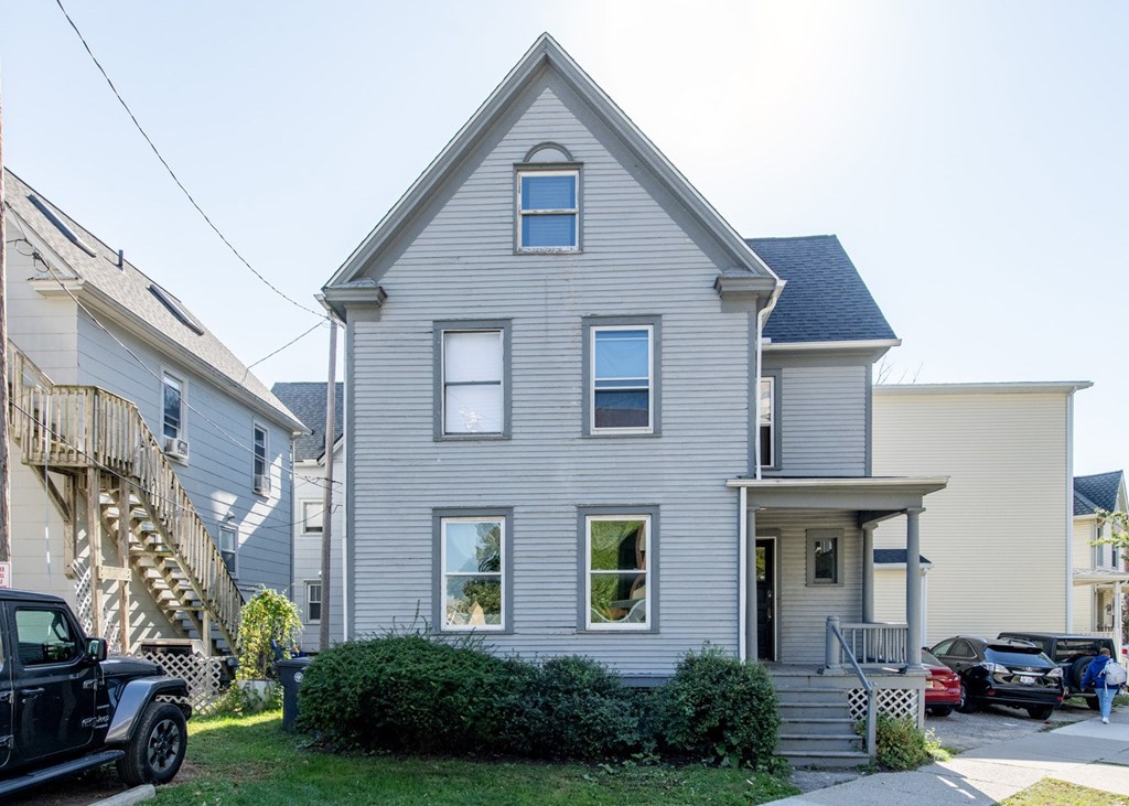A two-story house with a grey exterior and a small front porch.