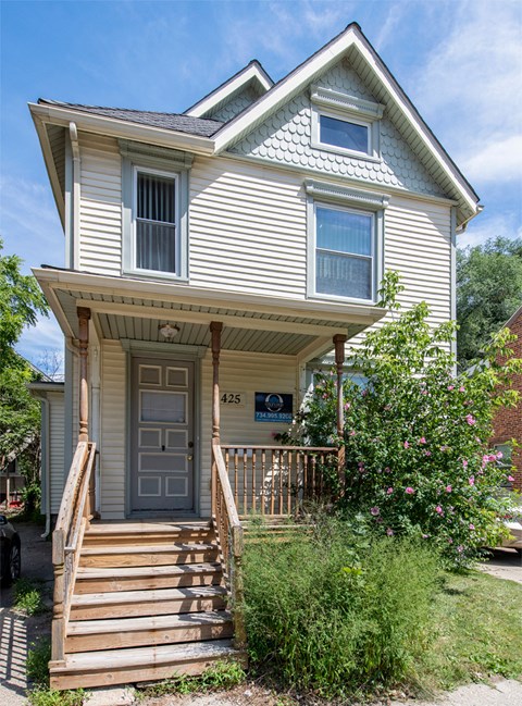 A two-story house with a grey front door and a porch.