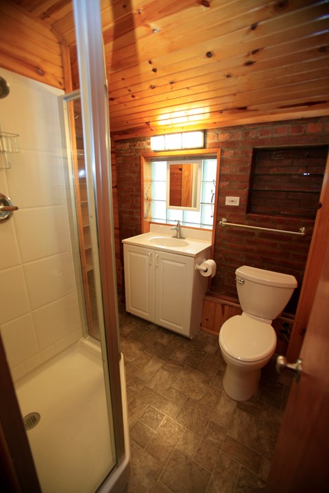 A small bathroom with a toilet, tub and window.