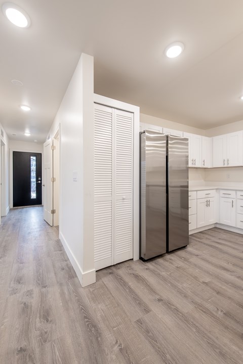 A kitchen with a refrigerator and cabinets.