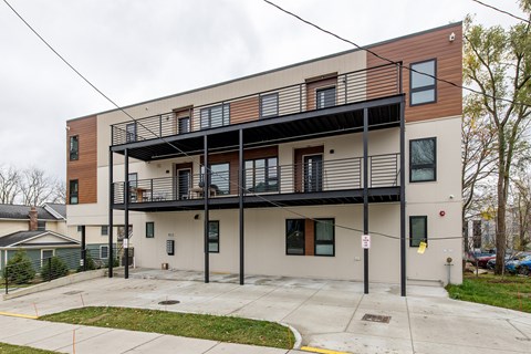 A modern two-story building with a balcony on the second floor.
