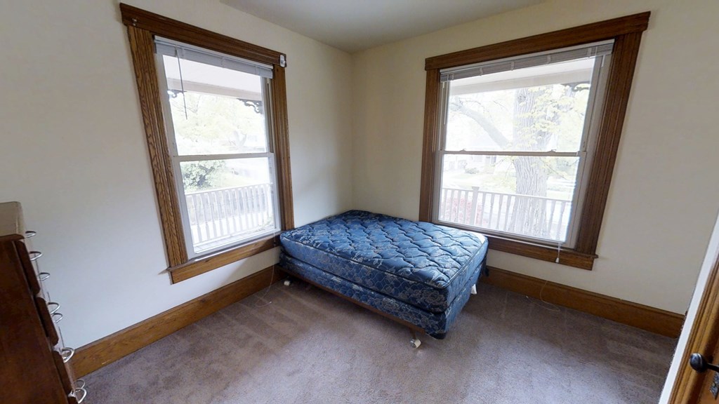 A bedroom with a bed in the middle of the room.