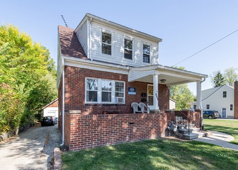 A small house with a red brick wall and a white section on top.