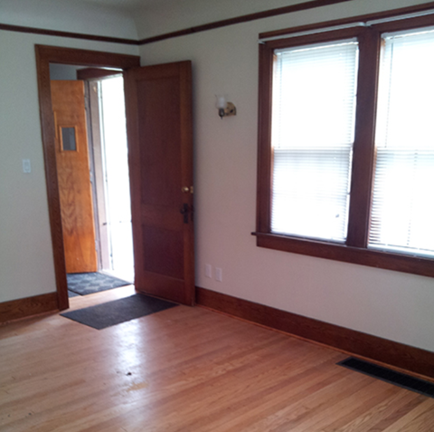A room with a wooden floor and a brown door.