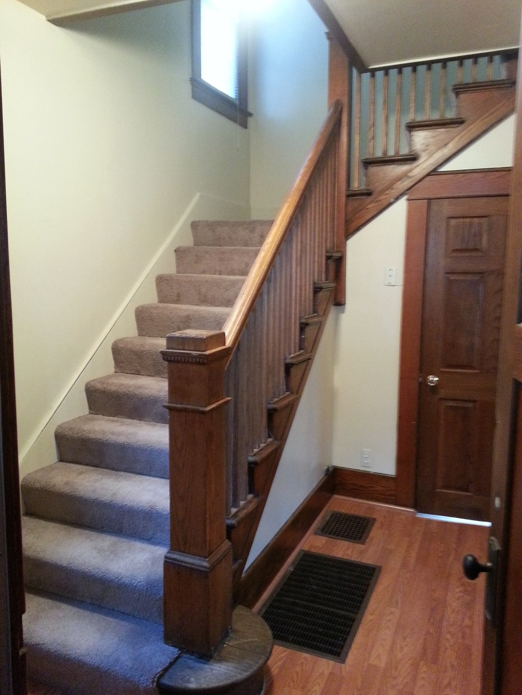 A staircase with a carpeted runner and wooden banister.