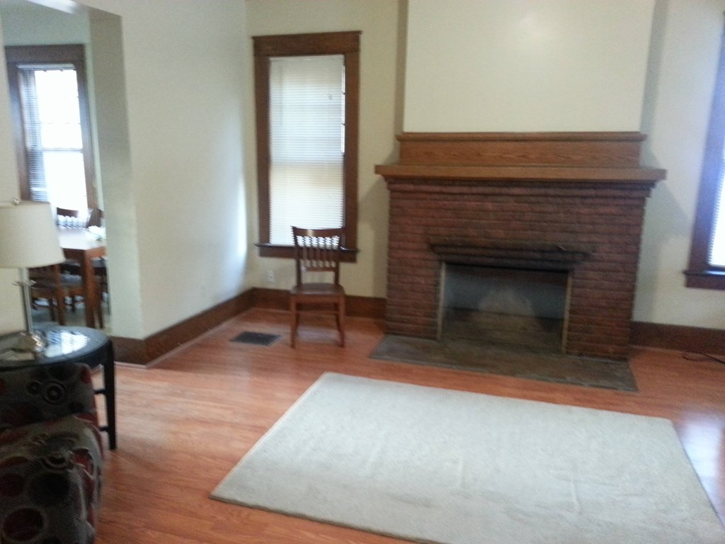 A living room with a fireplace and a chair.