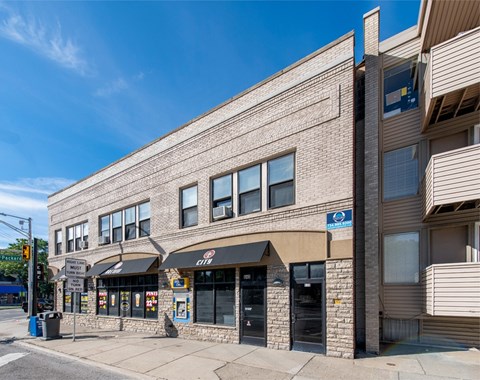A street view of a building with a blue sign on the right side.
