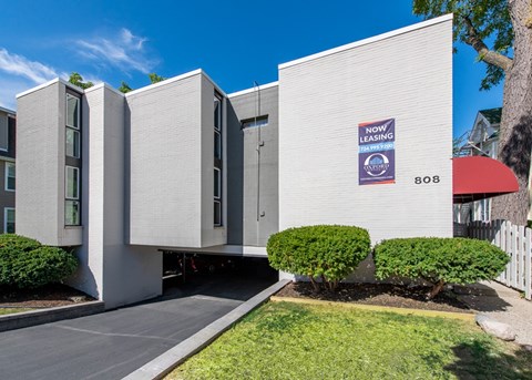 A modern building with a sign that says "NOW LEASING" and the number 808.