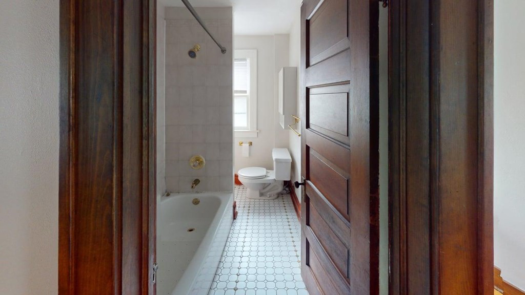 A bathroom with a toilet, sink and a shower.
