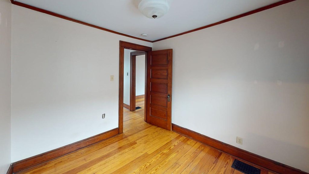 A room with a wooden floor and a brown door.