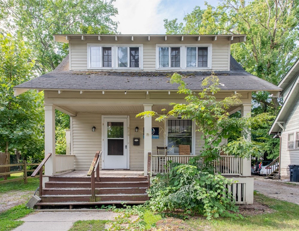 A small house with a front porch and a brown door.