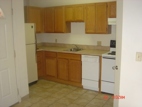 A kitchen with wooden cabinets and white appliances.