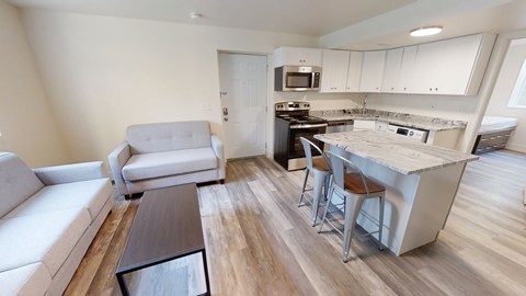 A modern kitchen with white cabinets and a wooden island.