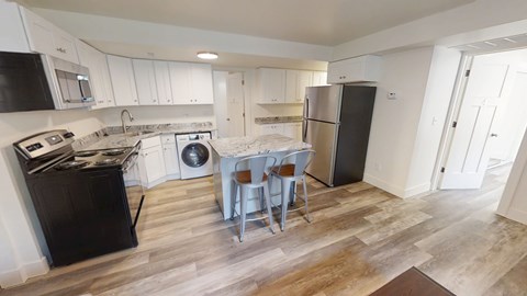 A kitchen with black appliances and white cabinets.