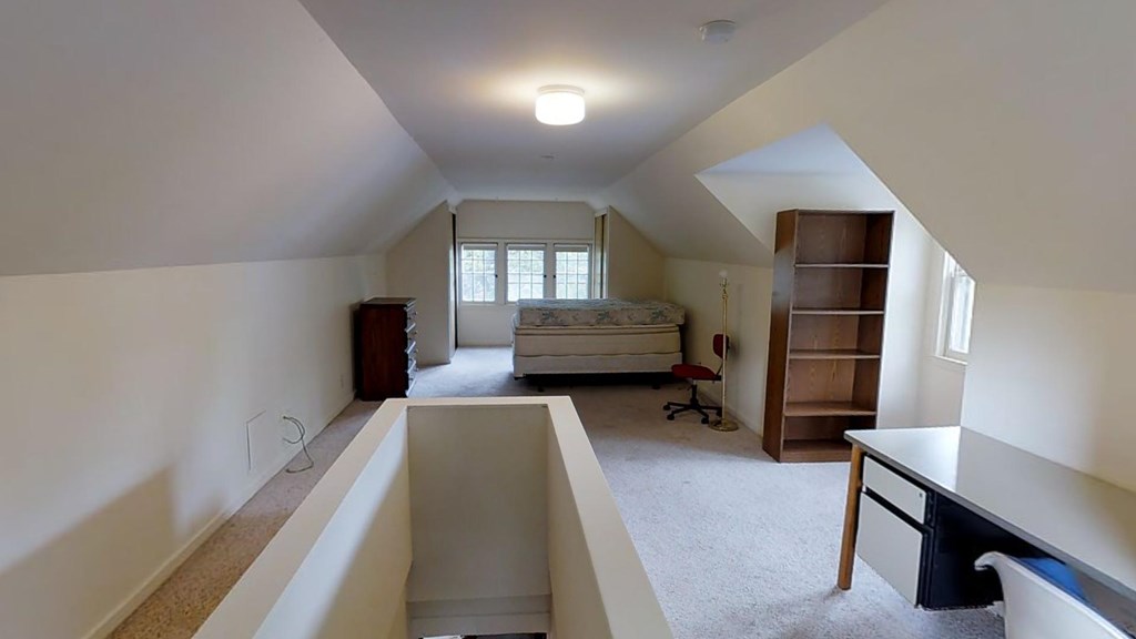 A room with a bed, desk, and chair.