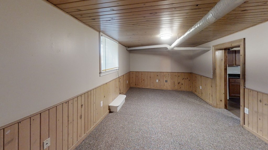 A room with wooden walls and a carpeted floor.
