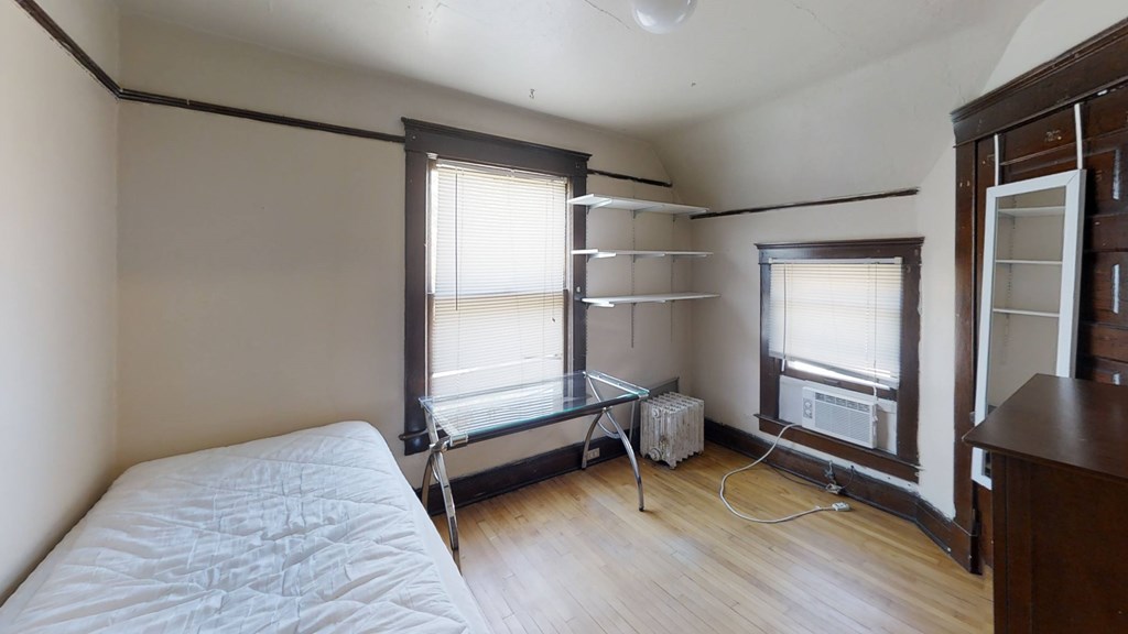 A room with a bed, a table, and a window.