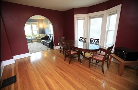 A dining room with a wooden table and chairs.