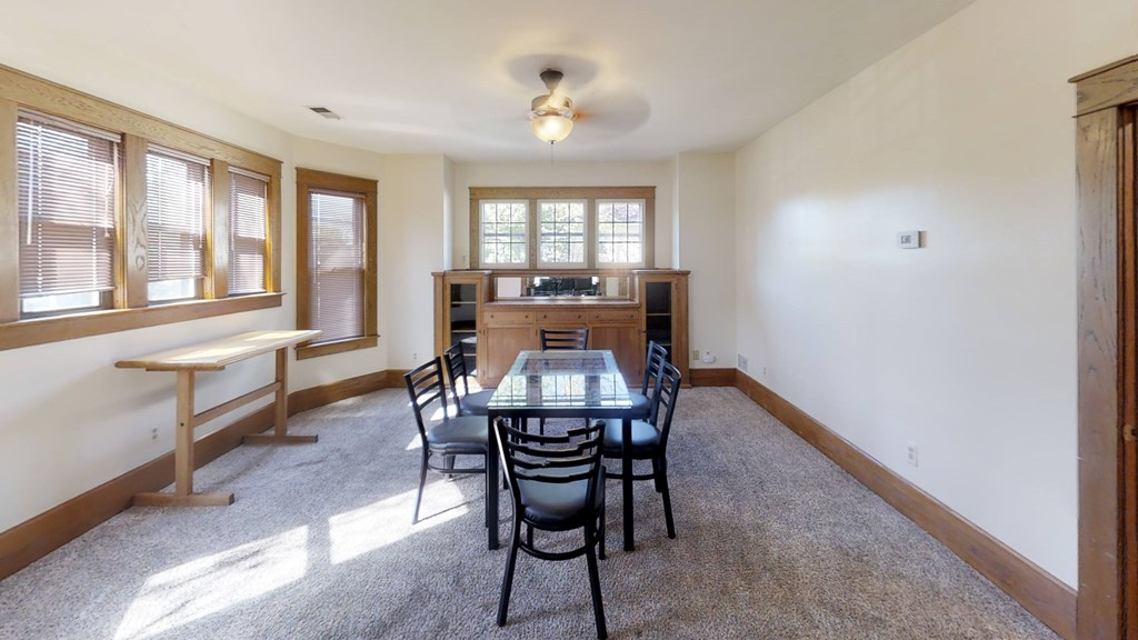 A dining room with a table and chairs.